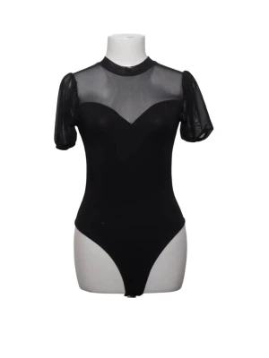Svart body - Snygg svart body med transparent mesh upptill och på ärmarna. Puffiga korta ärmar och snygg halsringning som ger en trendig look. Perfekt att styla till både jeans och kjol för en cool outfit.