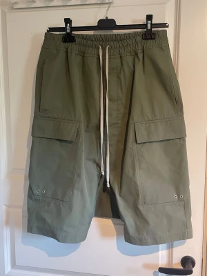 Rick owens cargo pod shorts - Ett par rick owens cargo pod shorts ifrån ss23(edfu) i colorwayen moss. Exremt bra skick och kvalitet. Size 48(M)