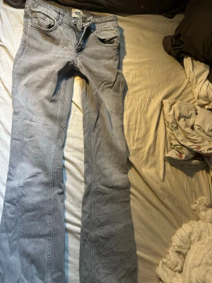 Ljusblå bootcut jeans - Säljer ett par ljusblå jeans med bootcut passform och klassiska fem fickor. Jeansen har låg midja och är tillverkade i ett mjukt denimtyg. Perfekta för dig som gillar en avslappnad men trendig look.