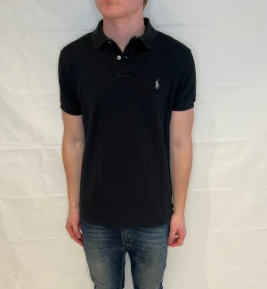 Polo Ralph Lauren Slim Fit Polo Black - Svart slim fit-pikétröja i 100% bomull, använd men i mycket gott skick.