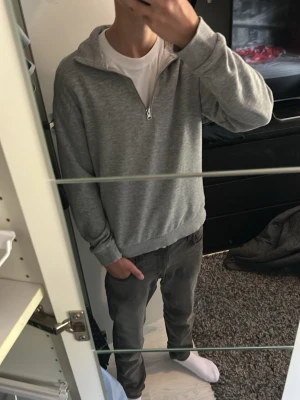 Grå halvzip tröja - Säljer en stilren grå tröja med halv dragkedja och hög krage. Tröjan har en relaxed passform och ribbade muddar vid ärmslut och nederkant. Perfekt för en avslappnad look och enkel att matcha med olika outfits.Rensar garderoben lite så priset går att diskutera. Skulle säga att den är som storlek 170. Skriv om det är några funderingar. 