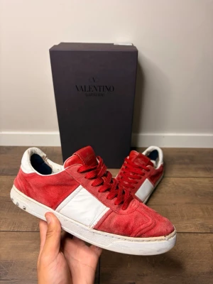 Valentino flycrews  - Snygga sneakers i röd mocka med vita läderdetaljer och matchande röda skosnören. Skorna har en vit sula och låg profil som ger en clean look. Perfekta för dig som vill sticka ut med färg och stil. Storlek 41 passar även 42. Obs endast skorna ingår 