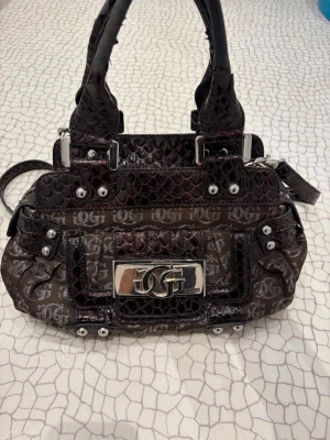 Vintage guess väska! - Säljer denna vintage guess väskan! Från 2005. Säljs dyrt då den köptes dyrt! Defekter: lädret vid handtaget har smulat sig, men inget som syns väldigt mycket! Äkta läder