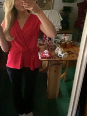 Röd omlottopp med knyt i midjan - Snygg röd omlottopp med v-ringning och knyt i midjan från Zara. Storlek XS. Endast använd 1 gång så i princip ny skick.