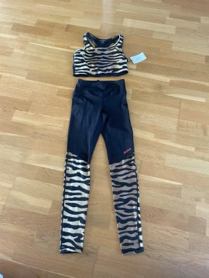 Träningsset från Björn Borg - Snyggt träningsset med sport-bh och tights från Björn Borg. Nyskick, aldrig använt och lapparna sitter kvar. Storlek 38 i toppen och 36 i byxorna. Priset är för båda, skrivet privat om ni endast vill köpa en. Pris kan diskuteras!