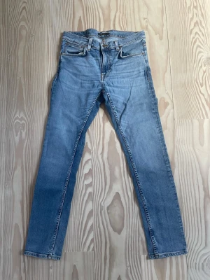Nudie Jeans - Säljer mina ljusblåa Nudie jeans i modellen Lean Dean. Byxorna är i storleken 32/32. Modellen lägger sig riktigt snyggt över benen och byxan går att matcha med allt!