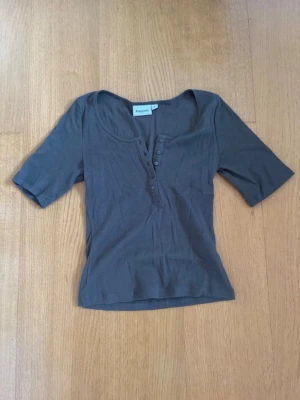 Slutsåld mörkgrön topp! - Helt slutsåld mörkgrön topp som inte kommer tillbaka i lager! Den är helt ny utan prislapp! Det är en ribbad topp med halvlånga ärmar och knappar framtill. Toppen har en djupare rundad urringning och är tillverkad i mjukt bomullsmaterial. Perfekt för hösten och vintern! Axelbredd: 34cm, längd: 49cm! Den kostar 250kr att köpa ny och jag säljer min för 215 då den är helt oanvänd utan prislapp och tröjan går inte längre att köpa! Skriv för frågor!