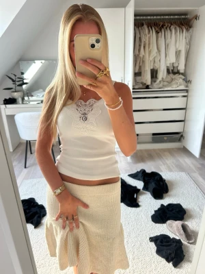 Beige stickad kjol med volang - Superfin beige stickad kjol med volangkant nertill. Kjolen har en mjuk och stretchig passform som sitter skönt i midjan. Perfekt för dig som gillar en feminin och trendig stil. Passar snyggt till både linne och stickad tröja.