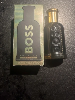 BOSS Bottled Absolu parfym 50 ml - 50ml kvar, Elegant parfym från BOSS, Bottled Absolu, i en stilren svart och guld glasflaska. Flaskan rymmer 50 ml och har en lyxig känsla med tydlig logga i relief. Kommer med originalkartong i matchande färger.
