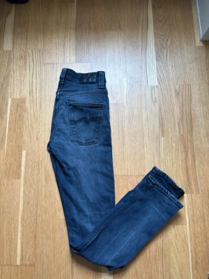  nudie jeans W29 L32 - Säljer ett par mörkblå jeans Perfekta till en avslappnad stil och passar till det mesta i garderoben. Från nudie i storlek W29 L32