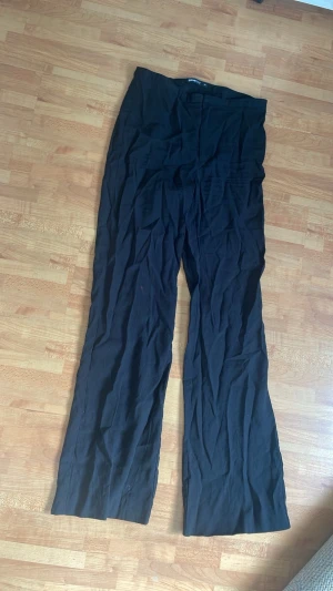 Svarta linnebyxor från Gina Tricot - Säljer ett par svarta linnebyxor från Gina Tricot i storlek 34. Byxorna har raka, vida ben och hög midja. Materialet är lätt och luftigt linne som passar bra till sommaren. Den har några tecken på användning 