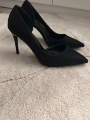 Svarta klassiska pumps med spetsig tå - klackar använda 1 gång ute då de är lite stora. super fina men lite dammiga för de bara har legat i garderoben. 