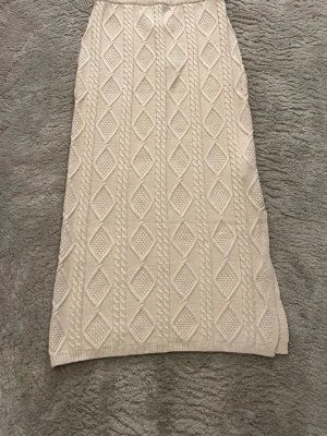 Beige stickad kjol med kabelmönster