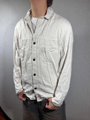 H&M overshirt M - Hej och välkommen till byTorén. Detta är en overshirt från H&M i storlek M med normal passform. Modell på bild är ca 182, 67kg. Plagget är i bra skick utan några defekter. Tveka inte på att höra av dig, även om det skulle vara minsta lilla;)