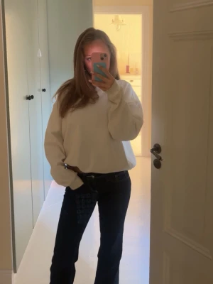 Vit oversized sweatshirt - Säljer en vit oversized sweatshirt med rund hals och långa ärmar. Tröjan har en avslappnad passform och är perfekt för en chill och enkel stil. Materialet är mjukt och bekvämt, perfekt att matcha med jeans eller leggings.