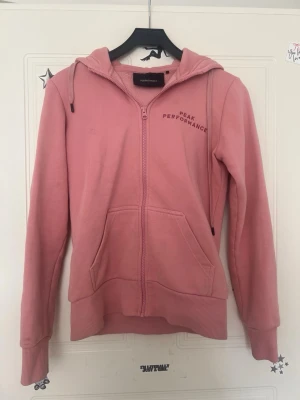 Rosa hoodie Peak Performance - Säljer en rosa hoodie från Peak Performance med dragkedja. Logga broderad på bröstet. Perfekt för chill dagar , går ej att köpa längre limited edition 
