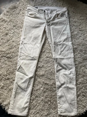 Vita jeans från J.Lindeberg - Snygga vita jeans från J.Lindeberg i rak modell. Klassisk femficksdesign med dragkedjegylf och knapp. Tillverkade i ett mjukt och bekvämt denimtyg som passar perfekt till många olika stilar.