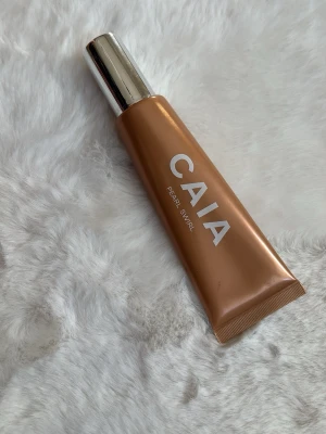 CAIA Pearl Swirl flytande highlighter - Flytande highlighter från CAIA i nyansen Pearl Swirl. Kommer i en snygg kopparfärgad tub med silverlock. Perfekt för att ge glow till ansiktet och framhäva kindbenen. Enkel att applicera tack vare smidig tubförpackning. Använd 1 gång.