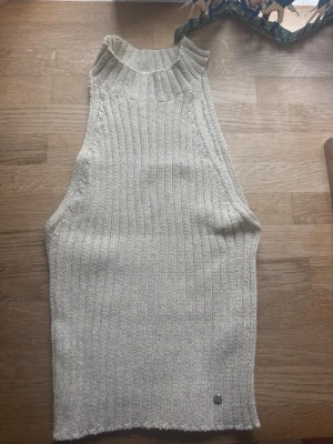 Ljusbeige ribbad stickad linnetopp - Säljer en ljusbeige ribbad stickad topp från Green Coast i storlek M. Tröjan har glitter i sig så ger en festlig känsla. Endast använd en gång och säljer den pgr av att den inte används. Det är en M men passar både Xs och S och kan även stretchas🩷