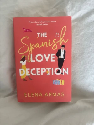 The Spanish Love Deception bok - En färgstark pocketbok med titeln 'The Spanish Love Deception' av Elena Armas. Omslaget är rött med illustrationer av en kvinna och en man, resväskor och ett flygplan. Boken är på engelska och handlar om romantik och förvecklingar i Spanien.