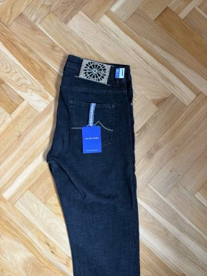  jeans från Jacob Cohën - Snygga jeans från Jacob Cohën med klassisk femficksmodell och raka ben. Jeansen har en unik patch med broderad detalj bak och blåa etiketter framtill. Tillverkade i ett mjukt denimtyg som ger en skön känsla och stilren look.