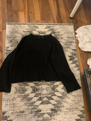 Svart stickad tröja från 157 - Säljer en svart stickad tröja från 157 med rund halsringning och avslappnad passform. Tröjan har långa ärmar och är perfekt för lager på lager. Enkel och stilren design som passar till det mesta.