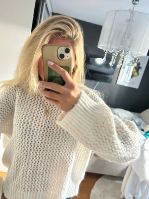 Vit chunky stickad tröja - Säljer en vit chunky stickad tröja med grovt hålmönster och bred ribbad kant vid halsen. Tröjan har långa ärmar och avslappnad passform, perfekt för lager på lager. Materialet känns mjukt och fluffigt. Köpt på target i usa. 