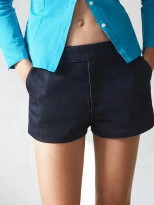 Zara shorts - Snygga mörkblå denimshorts med klassisk femficksdesign och bälteshällor. Shortsen har en rak passform och är perfekta för varma dagar. Stängs med dragkedja och knapp framtill. Enkelt att matcha med olika toppar för en cool look.
