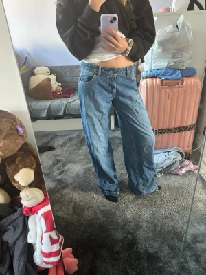  baggy jeans  - Säljer ett par blå baggy jeans med raka, vida ben och klassisk femficksdesign. Jeansen har hög midja och avslappnad passform, perfekta för en chill och trendig look. Materialet är denim i 100% bomull.