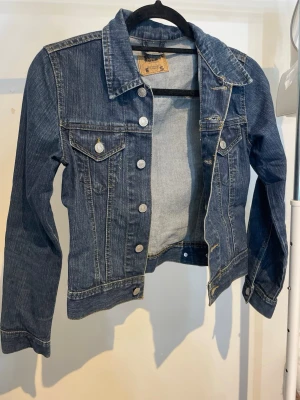 Jeansjacka - En blå jeansjacka från H&M, storlek XS.