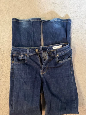 Mörkblå raka jeans från ZARA - Säljer ett par mörkblå jeans från ZARA med klassisk femficksmodell och raka ben. Jeansen har normal midja, gylf med dragkedja och knapp samt kontrastsömmar. Perfekta till en avslappnad stil och tillverkade i slitstarkt denimtyg.
