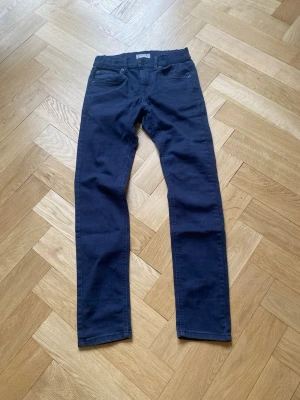 Mörkblå slim fit jeans - Snygga mörkblå jeans med slim fit passform och klassisk femficksdesign. Jeansen har raka ben och normal midja. Tillverkade i ett mjukt och stretchigt material som ger skön komfort hela dagen.
