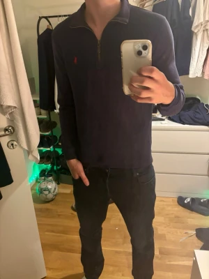 Mörkblå quarter zip från Polo Ralph Lauren - Mörkblå långärmad tröja med quarter zip och klassisk röd Polo Ralph Lauren-logga broderad på bröstet. 