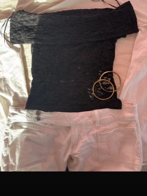 Svart spetsig offshoulder topp - ⚠️Sitter mer som S än M!⚠️Säljer en svart offshoulder topp i spets med transparenta detaljer. Toppen är tight och har snörning vid axlarna för extra stil. Perfekt för dig som vill ha en trendig och elegant look.