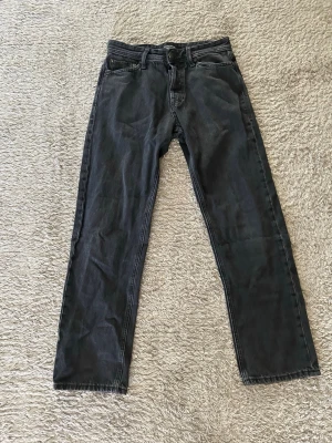 Svarta jack & jones jeans - Ett par svarta jeans med rak passform och klassisk femficksdesign. Jeansen har normal midja och stängs med dragkedja och knapp. Perfekta för en avslappnad och stilren look. Storlek 29/32 modellen relaxed Chris 