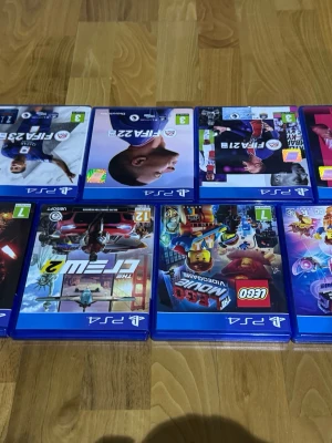 PS4 spelpaket med FIFA, LEGO & Crew - Säljer ett paket med PS4-spel: FIFA 22, FIFA 23, EA Sports FC 24, The Crew 2, LEGO Star Wars och LEGO Movie Videogame. Alla spel i blå plastfodral med färgglada omslag. Perfekt för dig som gillar sport, racing och äventyr.