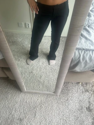 Kostymbyxor från bikbok  - Säljer ett par svarta kostymbyxor med bootcut ben och låg midja. Perfekta för en clean och stilren look. Modellen Vera i  Storlek 34petite.