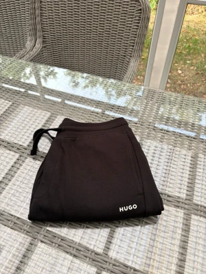 Svarta cuffed mjukisbyxor från HUGO storlek S - Svarta cuffed byxor från Hugo, äkta givetvis. Storlek S säljer då de blivit för små för mig. Bra skick!
