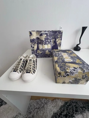 Dior Oblique låga sneakers - Snygga låga sneakers från Dior med klassiskt blått och vitt Oblique-mönster. Skorna har vita snören, gummisula och tydlig 'Christian Dior'-logga på plösen. Perfekta för dig som vill ha en exklusiv och trendig look.