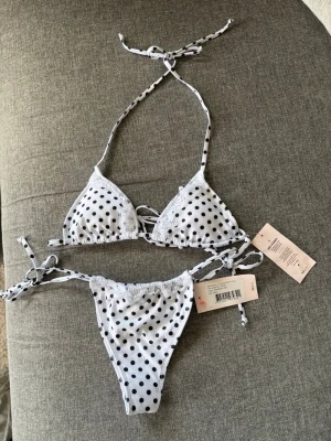 🤍 Nelly prickig bikini – NY med lappar! 🤍 - Säljer denna superfina bikini från Nelly som är helt ny och oanvänd, fortfarande med lappar kvar. 🌸  • 🤍 Vit med svarta prickar & fina spetsdetaljer • 🎀 Justerbara knytband i nacke, rygg och sidor för perfekt passform • 👙 Topp: XS • 👙 Trosa: S • ✨ Helt ny – aldrig använd, lappar kvar