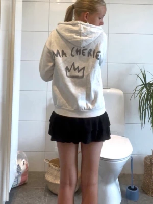 Grå hoodie med tryck 'MA CHÉRIE' - Ljusgrå hoodie med huva och snören och tryck 'MA CHÉRIE'. 