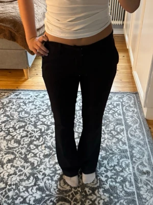 Svarta kostymbyxor - Kostymbyxor från Gina med låg midja. Har en liten skada vid ena bakfickan som nästan inte syns, kan skicka bild vid behov och intresse. 