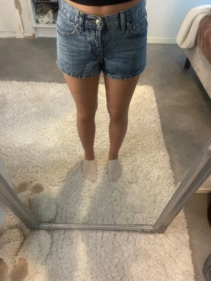 Jeans shorts  - Mid waisted shorts med broderi på bakfickorna, storlek XS