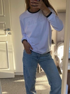 Pullover med OXFORD-tryck - Pullover med upphöjt OXFORD-tryck på bröstet. Svarta detaljer vid halsringning och ärmslut ger en sportig touch. Perfekt till jeans eller kjol för en avslappnad look.
