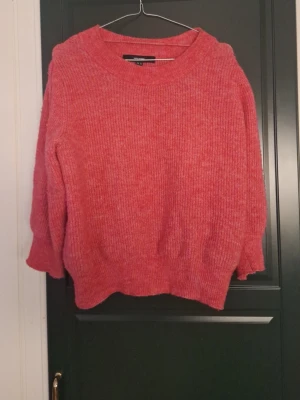 Rosa stickad tröja - Den är mer rosa än på bilden. Halvkorta ärmar. Använd ett fåtal gånger. Formar midjan bra eftersom den är lite "indragen" längst ner.