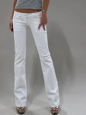 Vita  jeans med fickor fram och bak  - Snygga vita jeans med bootcut passform och stora fickor fram. Jeansen har även fickor bak med lock och guldfärgade knappar. Tillverkade i ett stretchigt material för skön passform och stilren look.