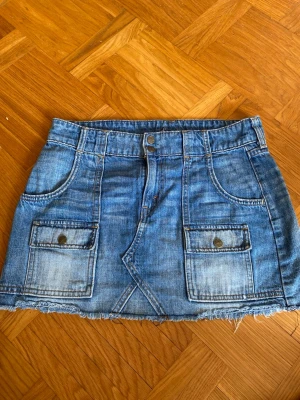 Levis Jeanskjol - Säljer en blå jeanskjol i kort modell med fickor fram och bak.