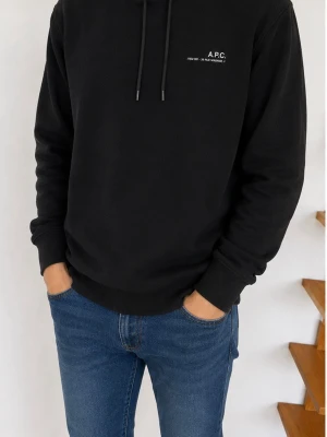 Svart hoodie från A.P.C. - Snygg svart hoodie från A.P.C. med minimalistisk vit logga på bröstet. Klassisk passform med huva och dragsko samt ribbade muddar vid ärmslut och nederkant. Perfekt till jeans för en clean och stilren look.