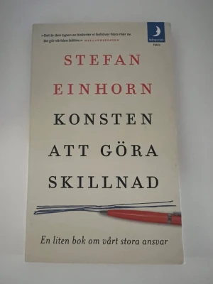 Konsten att göra skillnad - En inspirerande bok av Stefan Einhorn om hur vi alla kan bidra till en bättre värld. Boken är i pocketformat med vit framsida, svart och röd text samt en illustration av en penna. Perfekt för dig som vill läsa om ansvar och förändring.
