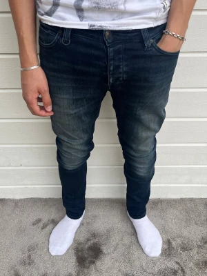 Neuw jeans mörkblå med tvött - Hej, säljer dessa Neuw jeans med snygg tvätt. Modellen på bilden är 183cm och väger 68kg. Jeansen är i ett gott skick i helhet och trådlösning syns på sista bilden men går enkelt att sy ihop med nål och tråd! Passform: slim och storleken är W30/L32. Hör av dig vid frågor/funderingar! Mvh DC ♦️